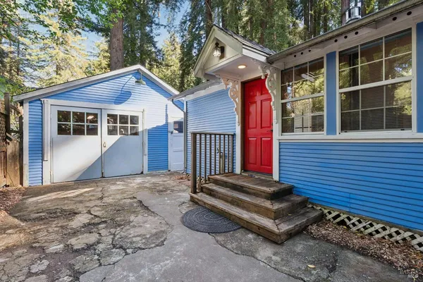 a front view of a house with a yard and potted plants