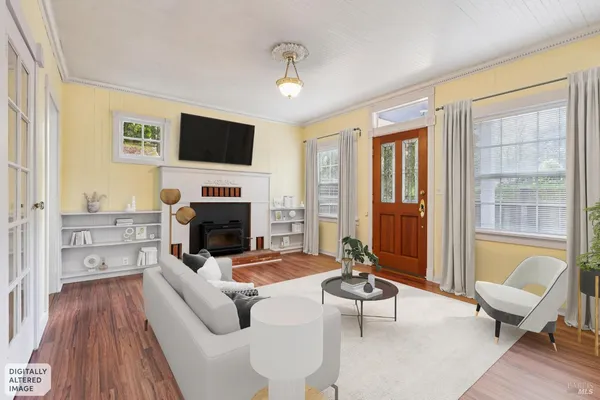 a view of an empty room with wooden floor fireplace and a window
