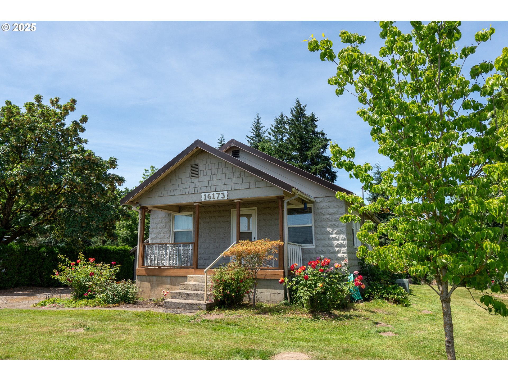 16163 French Prairie Road Northeast Woodburn, OR 97071 - Photo 3 of 47 a front view of a house with a yard and potted plants