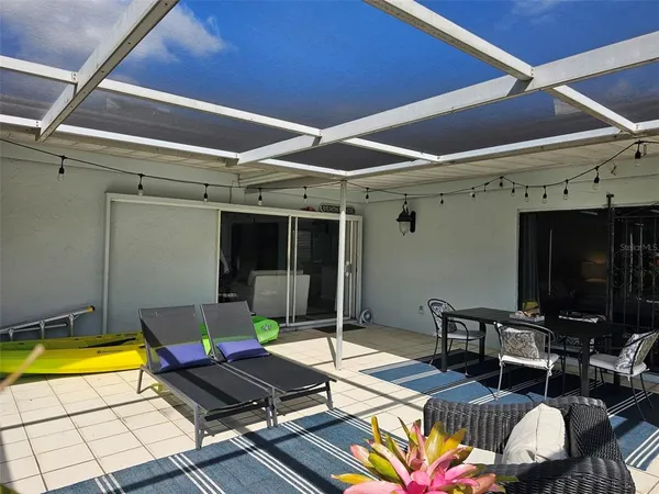 a living room with patio furniture and a floor to ceiling window