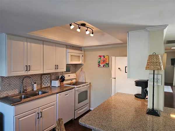 a kitchen with kitchen island white cabinets and refrigerator