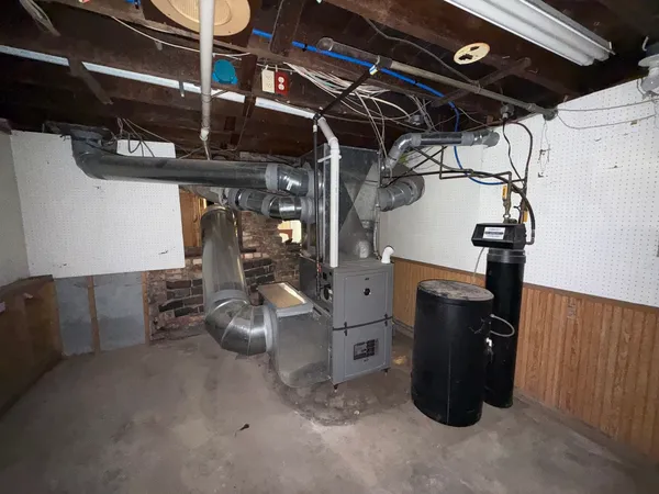 an empty room with chandelier fan and windows