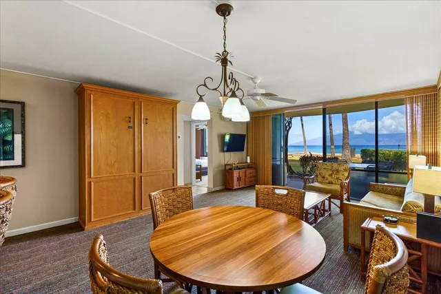 a room with wooden floor pool table and chairs
