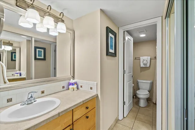 a bathroom with a granite countertop sink mirror and toilet