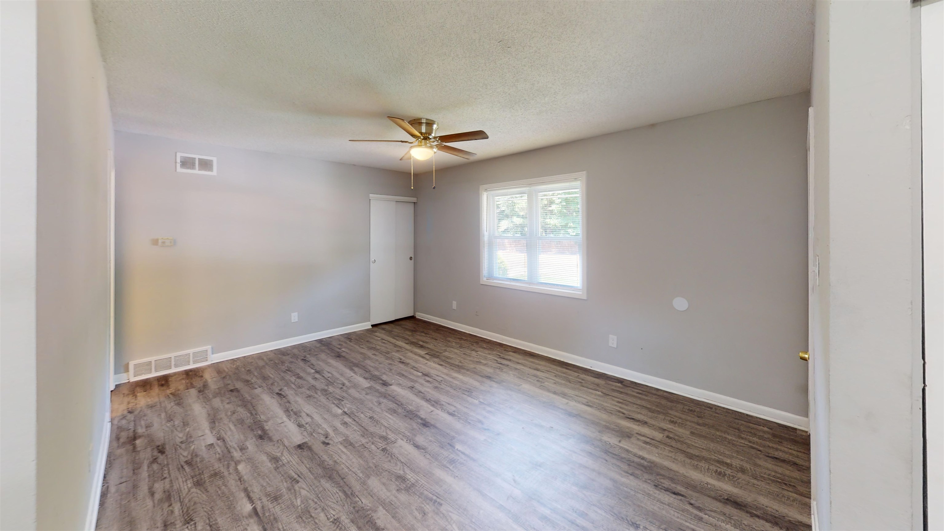 667 West Raines Road Memphis, TN 38109 - Photo 5 of 15 an empty room with wooden floor ceiling fan and windows