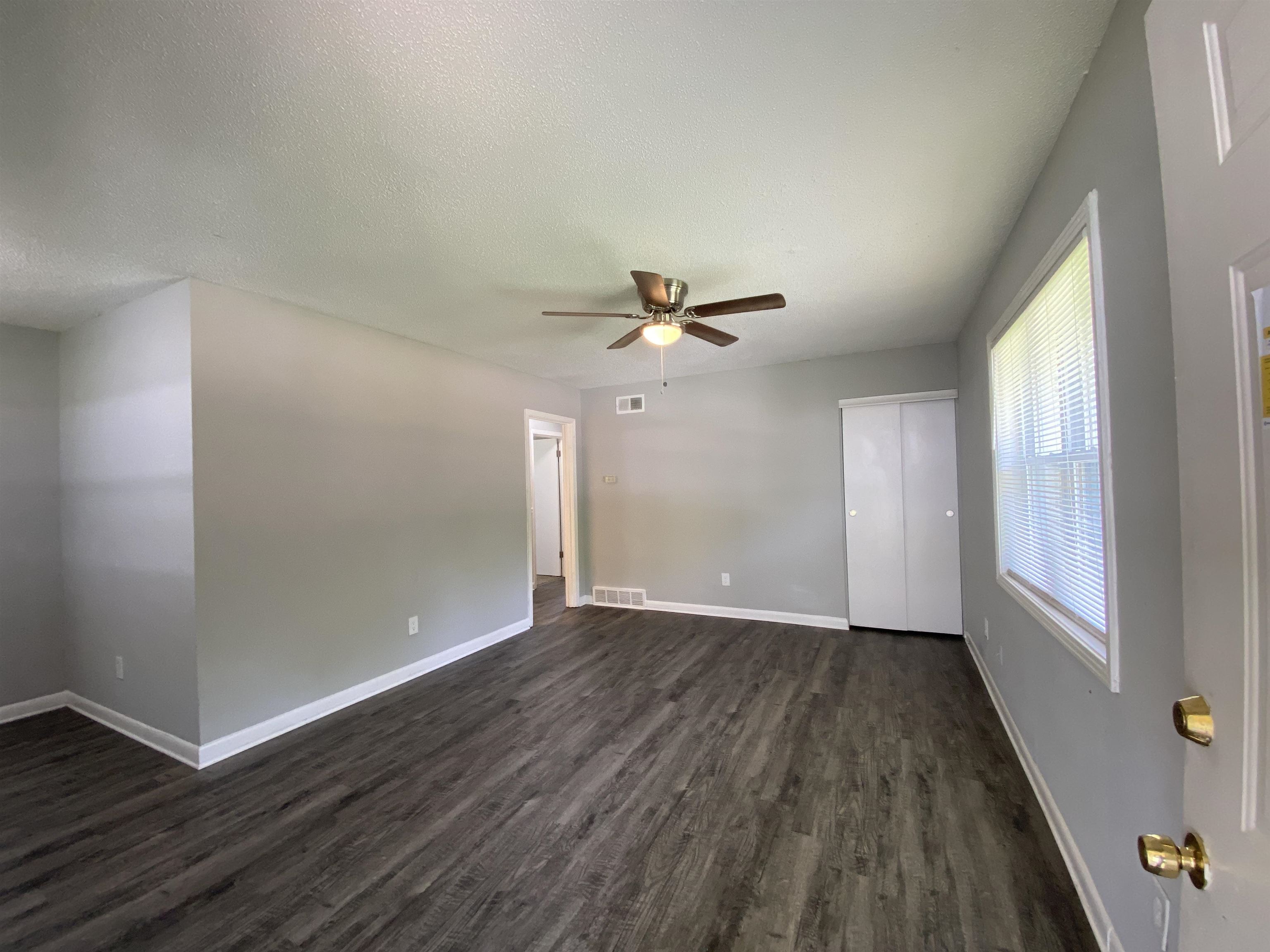 667 West Raines Road Memphis, TN 38109 - Photo 8 of 15 an empty room with wooden floor fan and windows