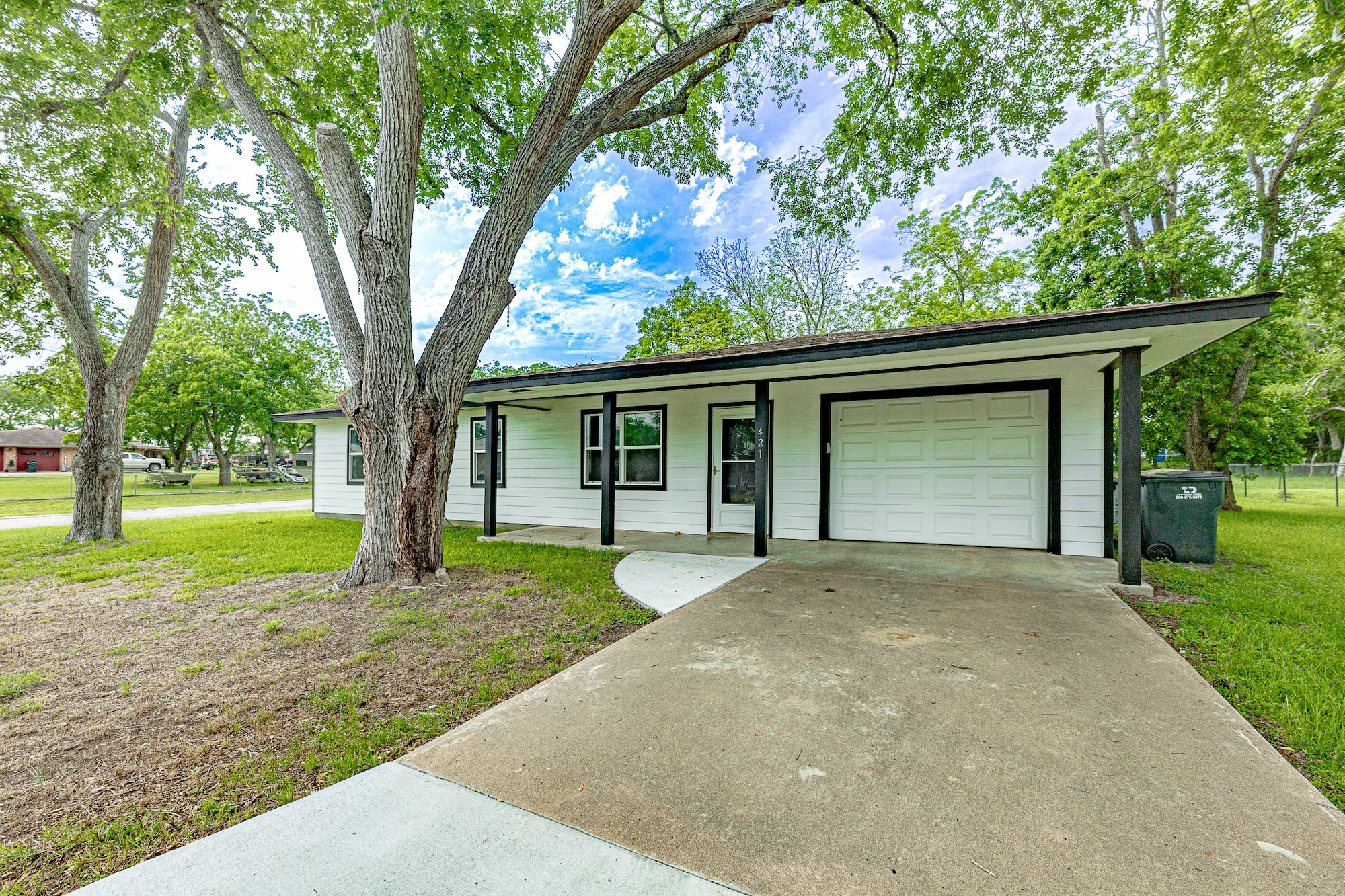 421 West Runk Street Shiner, TX 77984 - Photo 1 of 18 front view of a house with a yard and an trees