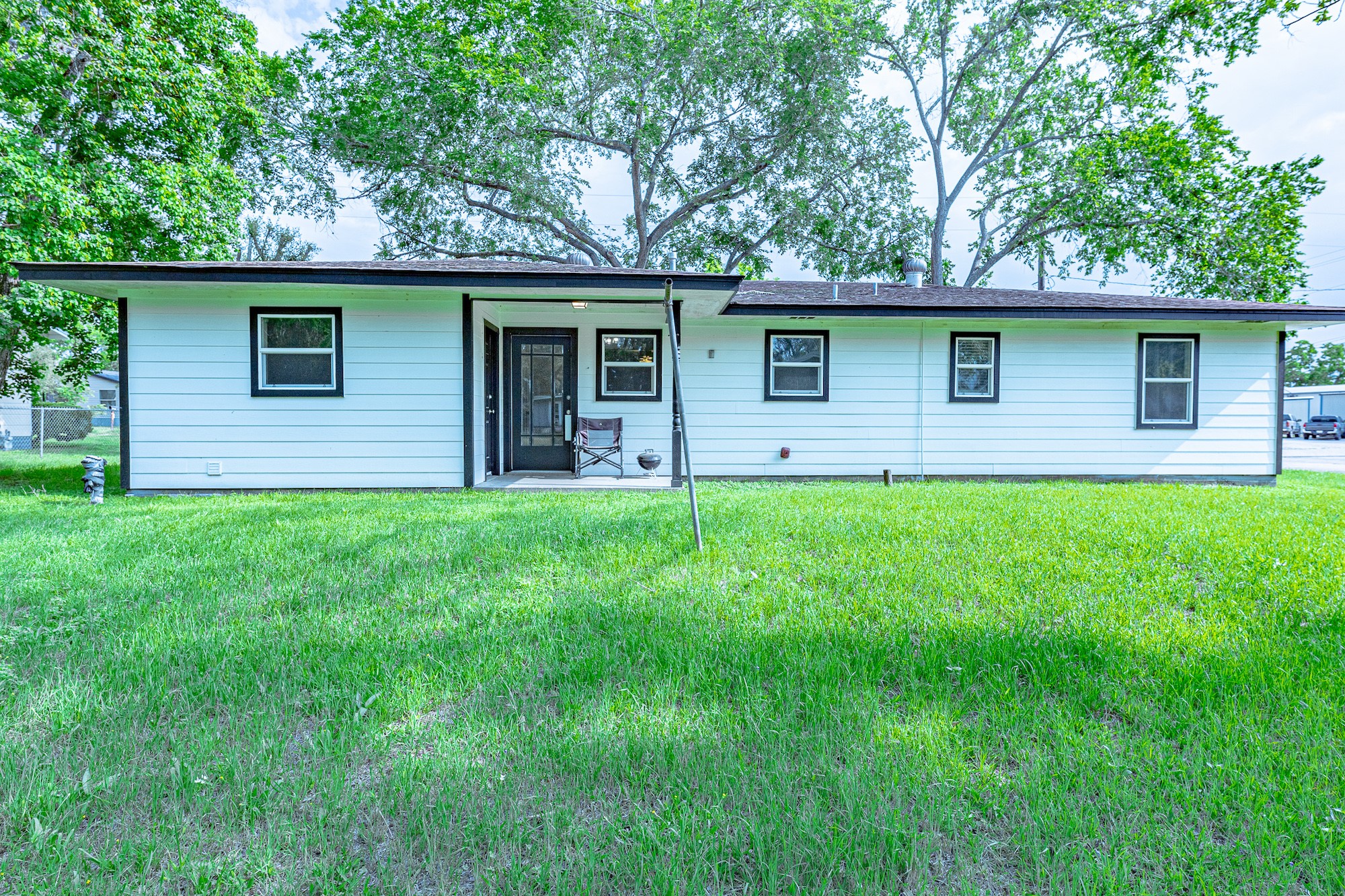 421 West Runk Street Shiner, TX 77984 - Photo 17 of 18 a brick house in front of a yard with large tree