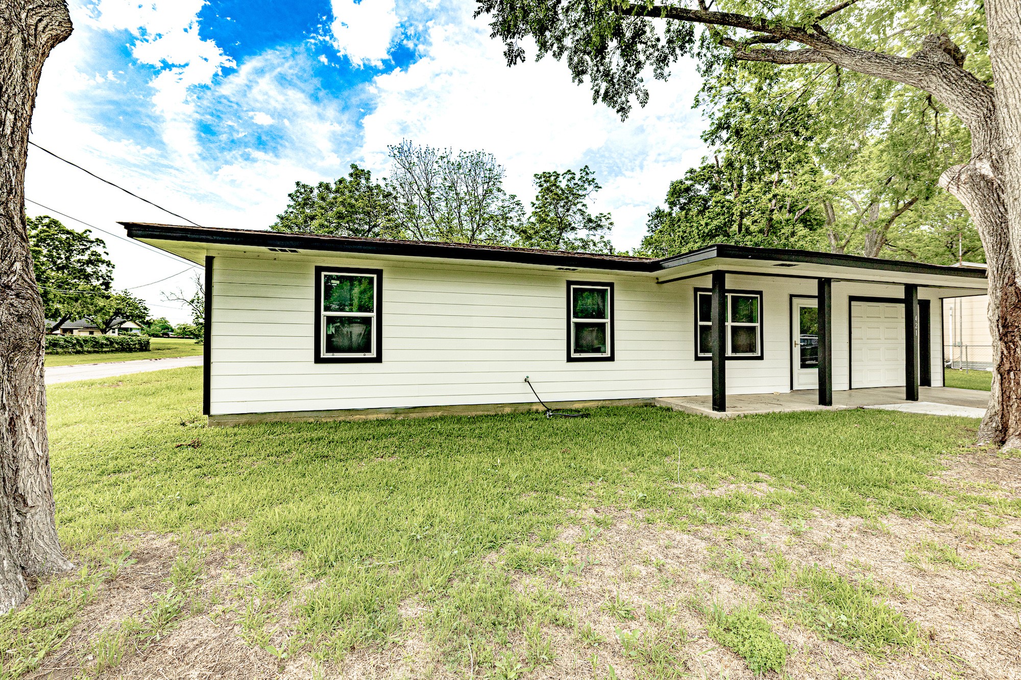 421 West Runk Street Shiner, TX 77984 - Photo 2 of 18 a backyard of a house with plants and large trees