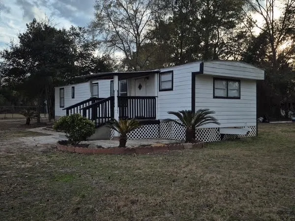 a view of a house with a yard and deck