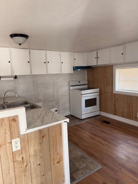 15110 Firetower Road Conroe, TX 77306 - Photo 4 of 14 a kitchen with stainless steel appliances granite countertop a sink a stove a refrigerator and white cabinets with wooden floor