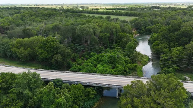 a view of a lake with a yard and large trees