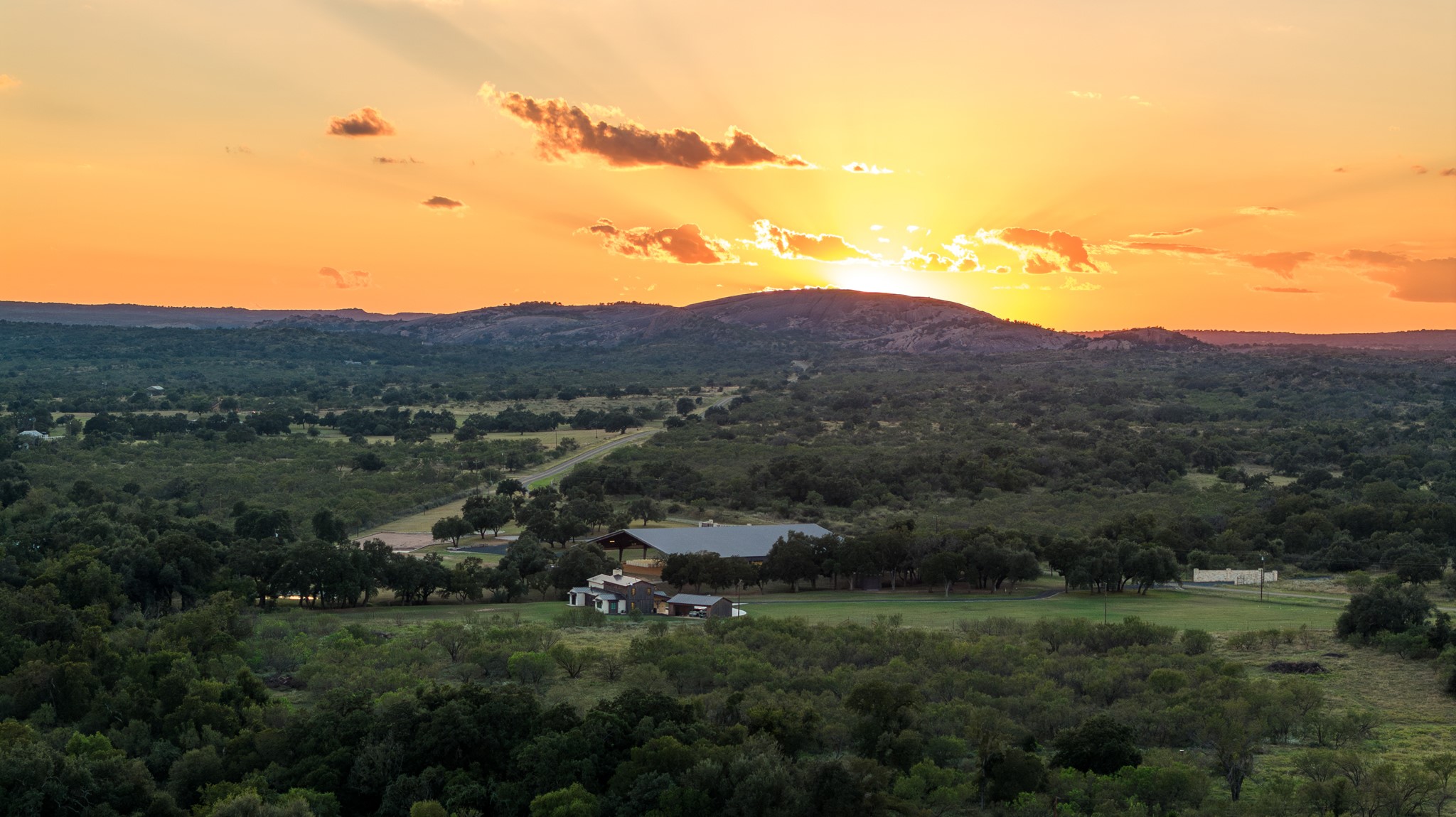 5862 Ranch Road 965 Llano, TX 78643 - Photo 2 of 40 a view of a lush green hillside and a building