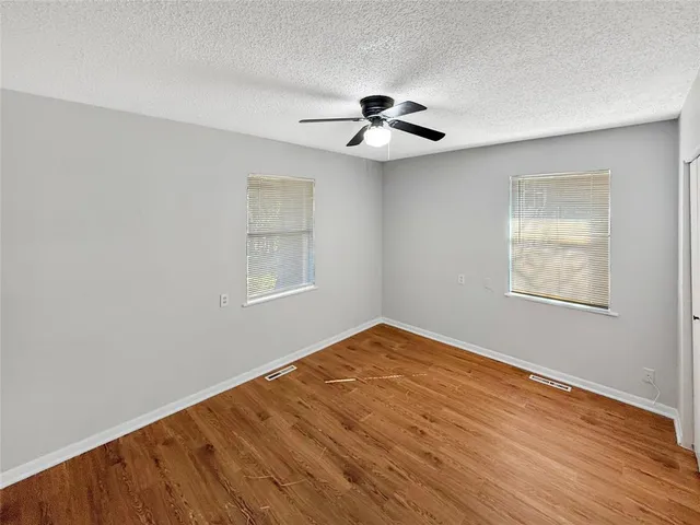 wooden floor in an empty room with a kitchen