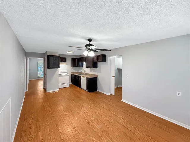 a spacious bedroom with a large bed a chandelier and a flat tv screen