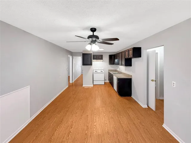 a kitchen with granite countertop a sink stove and cabinets