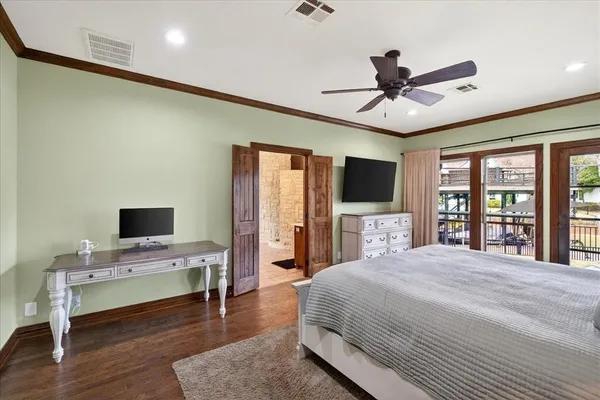 a spacious bedroom with a bed and a flat screen tv