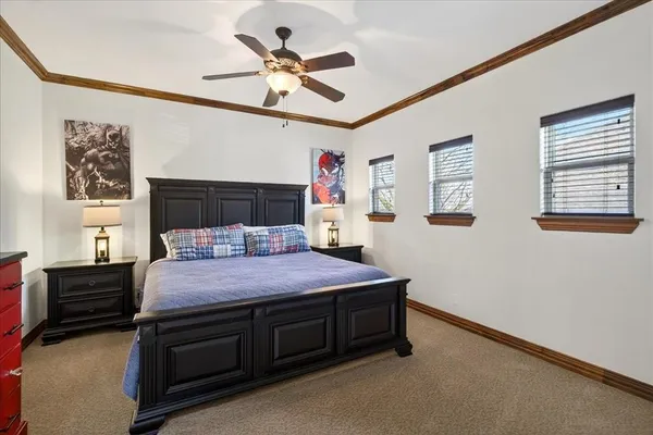 a bedroom with a bed a dresser and paintings on the wall