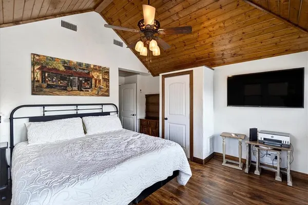 a bedroom with a bed a flat screen tv and dresser