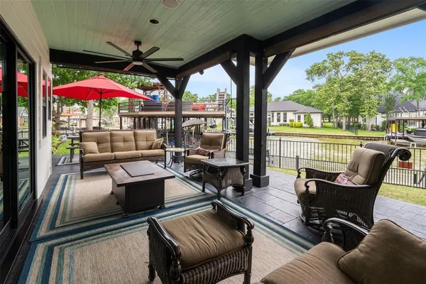 an outdoor sitting area with furniture and umbrella