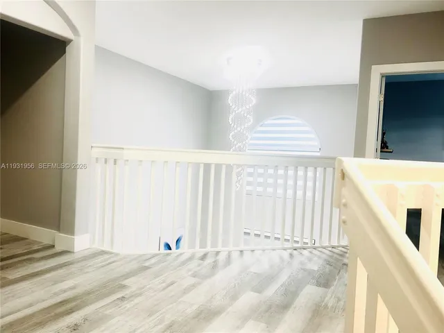 a view of a bedroom with wooden floor and a window