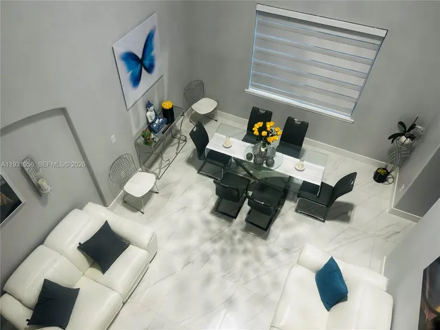 a living room with furniture and a painting on the wall