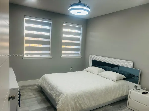a large bed sitting in a bedroom next to a window