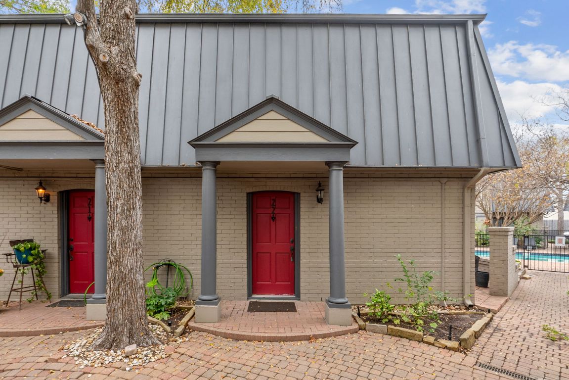 View of front of house with a porch, a standing seam roof, brick siding, and a metal roof