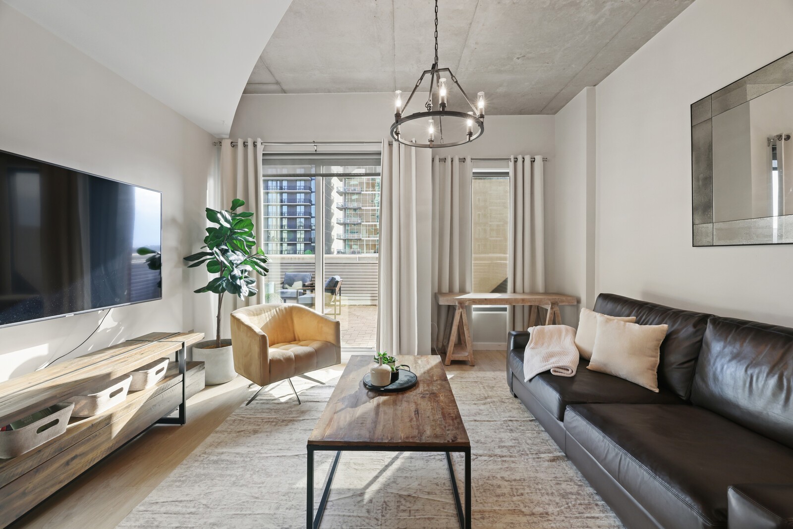 600 12th Avenue South, Unit 910 Nashville, TN 37203 - Photo 3 of 15 a living room with furniture and a flat screen tv