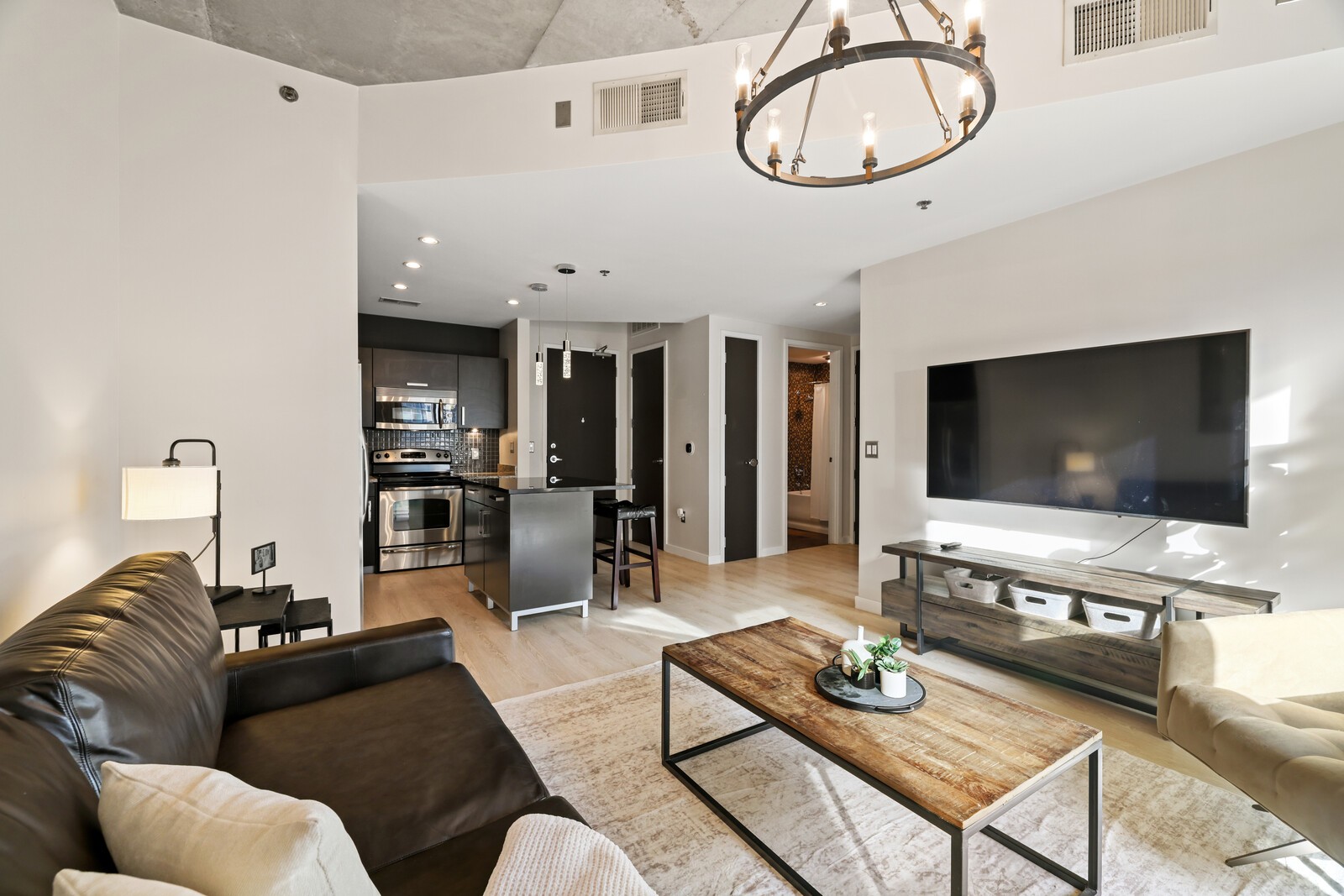 600 12th Avenue South, Unit 910 Nashville, TN 37203 - Photo 5 of 15 a living room with furniture a dining table and a flat screen tv