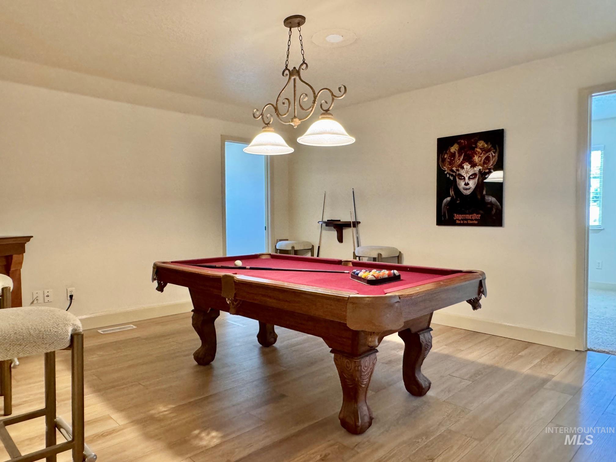 9299 Kemp Road Middleton, ID 83644 - Photo 30 of 50 Spacious room featuring wood-finish flooring and a central chandelier