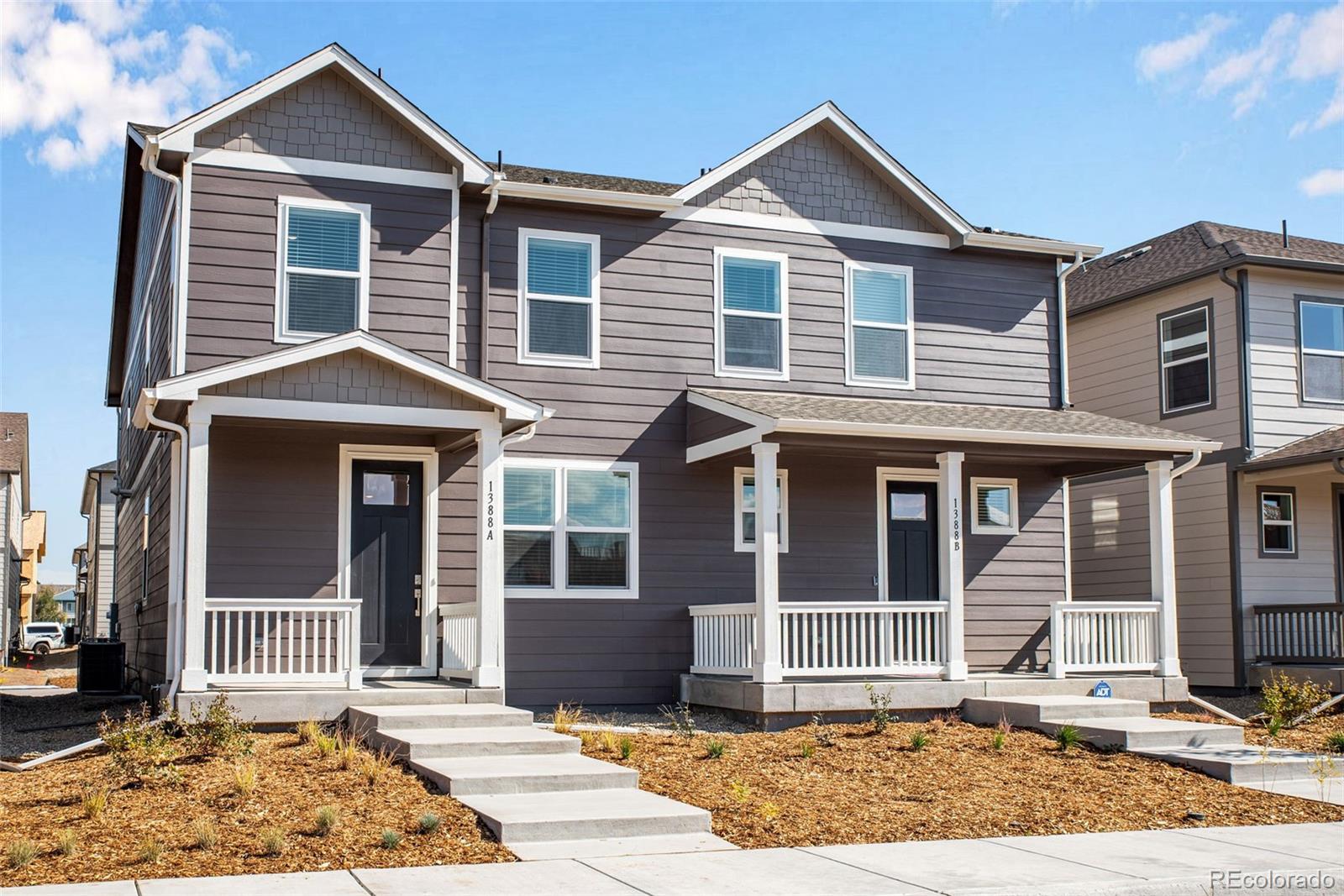 1357 South Chester Street, Unit B Denver, CO 80247 - Photo 2 of 18 a front view of a house with a yard and glass windows