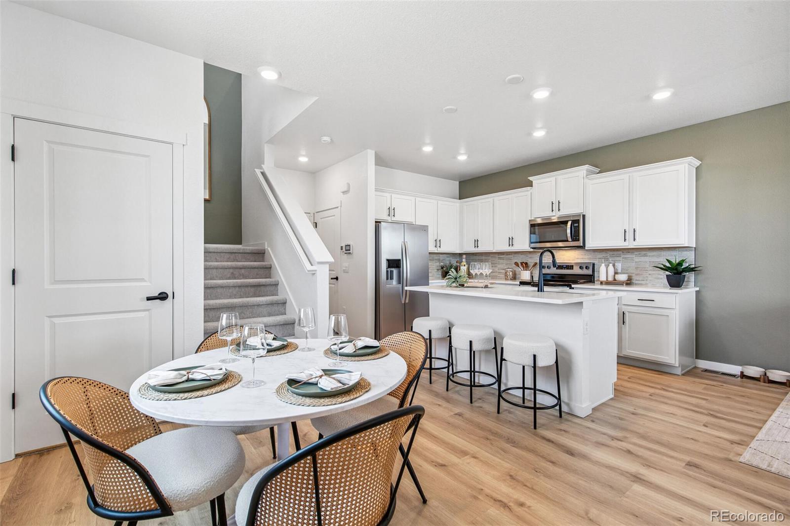 1357 South Chester Street, Unit B Denver, CO 80247 - Photo 10 of 18 a kitchen with a dining table chairs and wooden floor