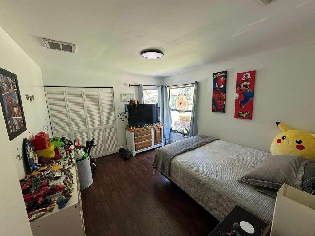 20780 Boca Ridge Drive North, Unit 20780 Boca Raton, FL 33428 - Photo 15 of 35 a bedroom with a bed and wooden floor