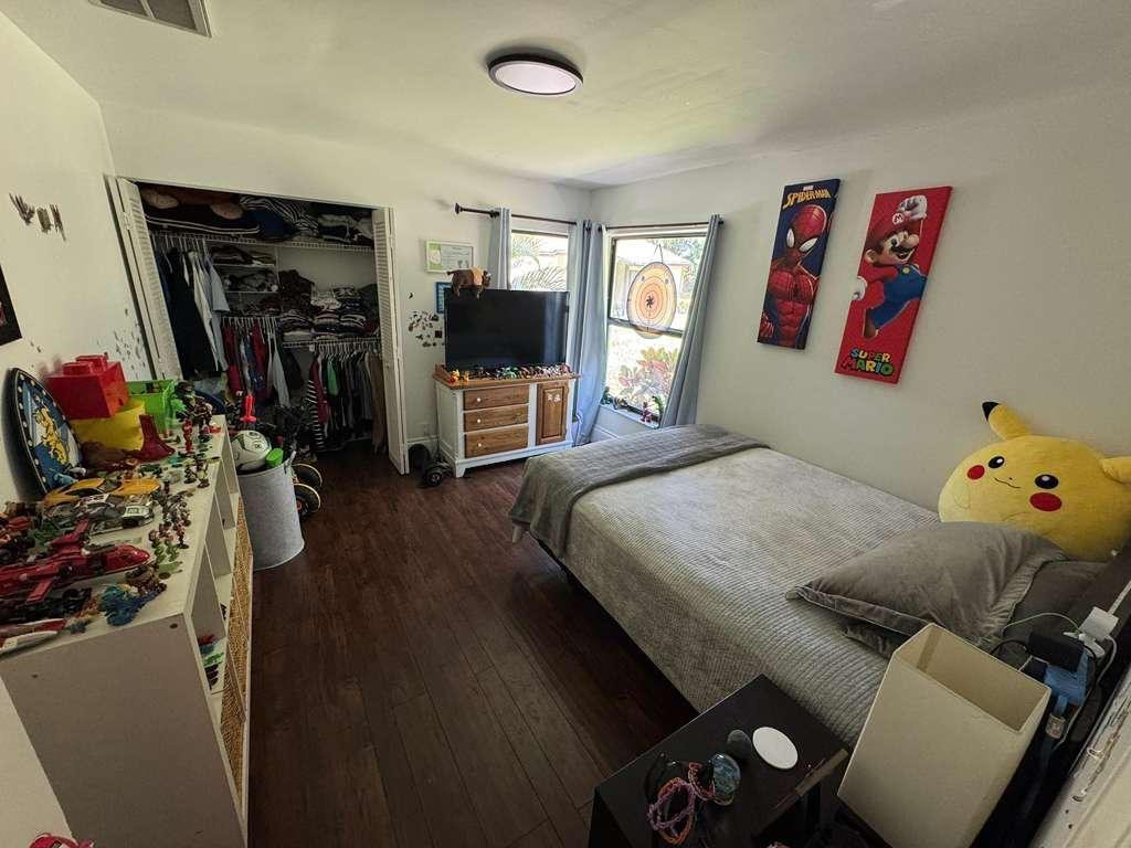 20780 Boca Ridge Drive North, Unit 20780 Boca Raton, FL 33428 - Photo 16 of 35 a bedroom with a bed and a flat tv screen on the dresser