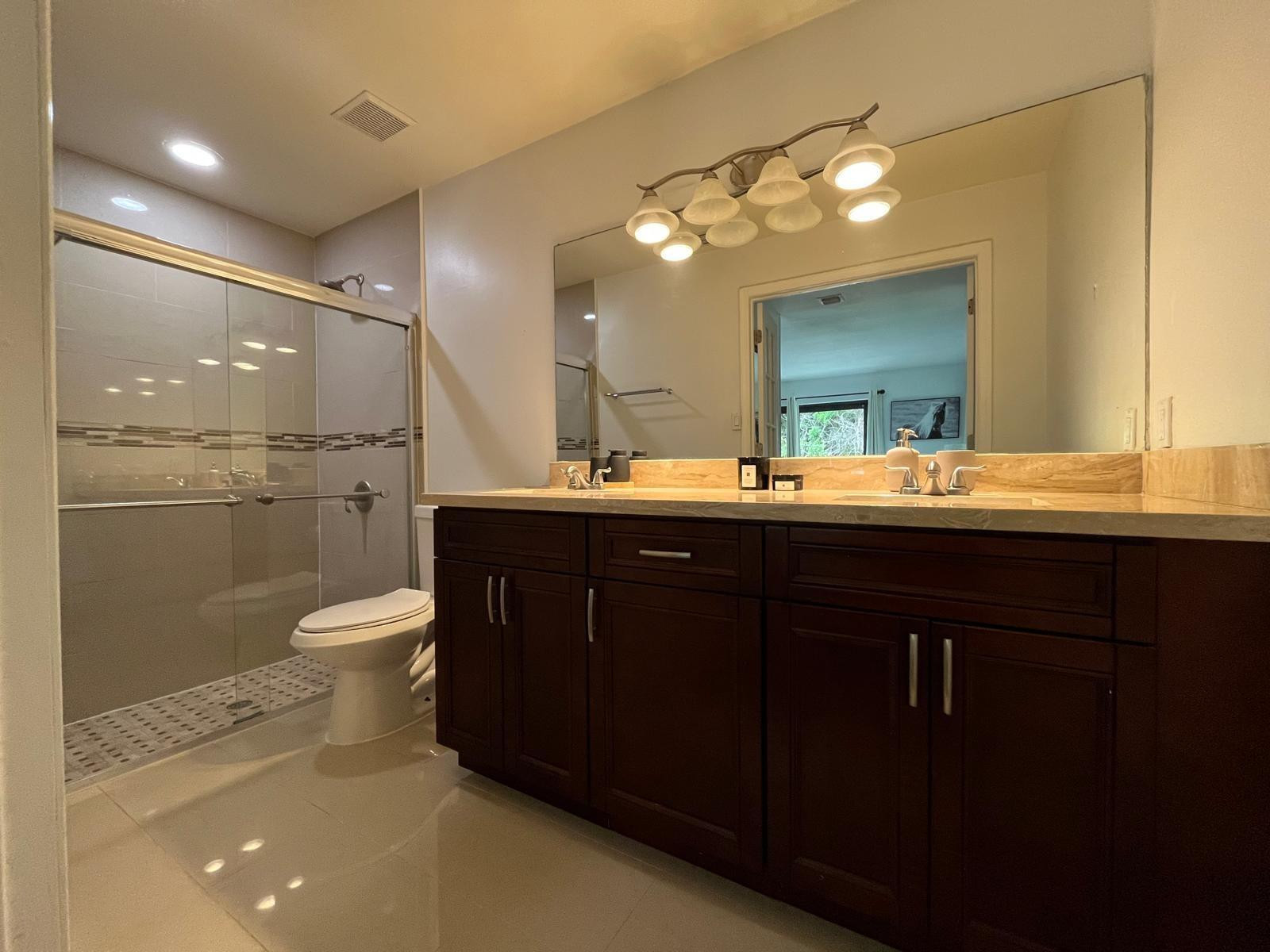 20780 Boca Ridge Drive North, Unit 20780 Boca Raton, FL 33428 - Photo 17 of 35 a bathroom with a double vanity sink toilet and a mirror