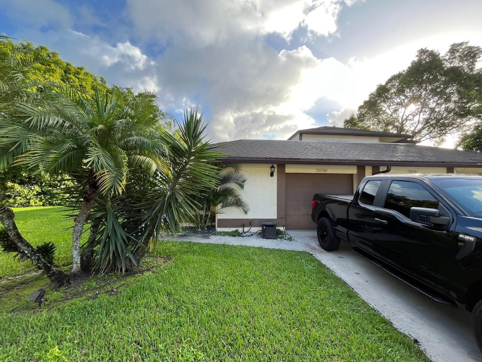 20780 Boca Ridge Drive North, Unit 20780 Boca Raton, FL 33428 - Photo 2 of 35 a view of a backyard with couches plants and large trees