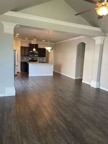 a view of a big room with wooden floor and a kitchen