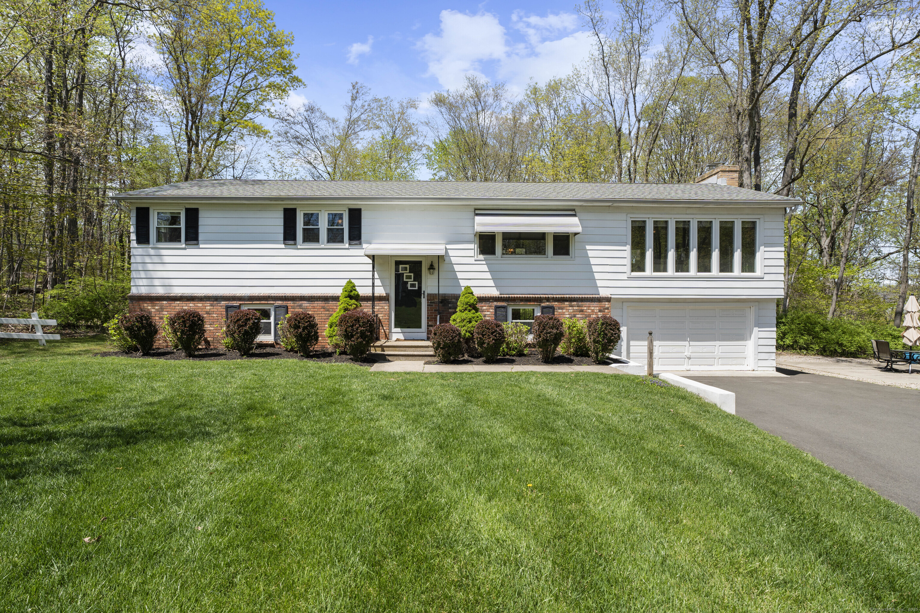 a front view of house with yard and trees in the background