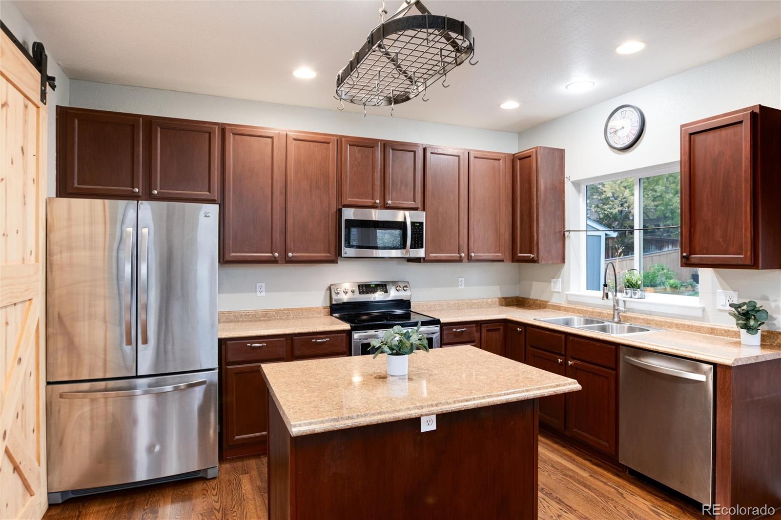 9218 Fox Fire Lane Highlands Ranch, CO 80129 - Photo 12 of 38 a kitchen with a sink a refrigerator a stove and microwave