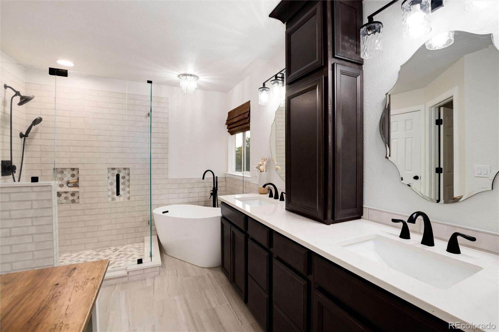 9218 Fox Fire Lane Highlands Ranch, CO 80129 - Photo 24 of 38 a spacious bathroom with a double vanity sink a large mirror and shower