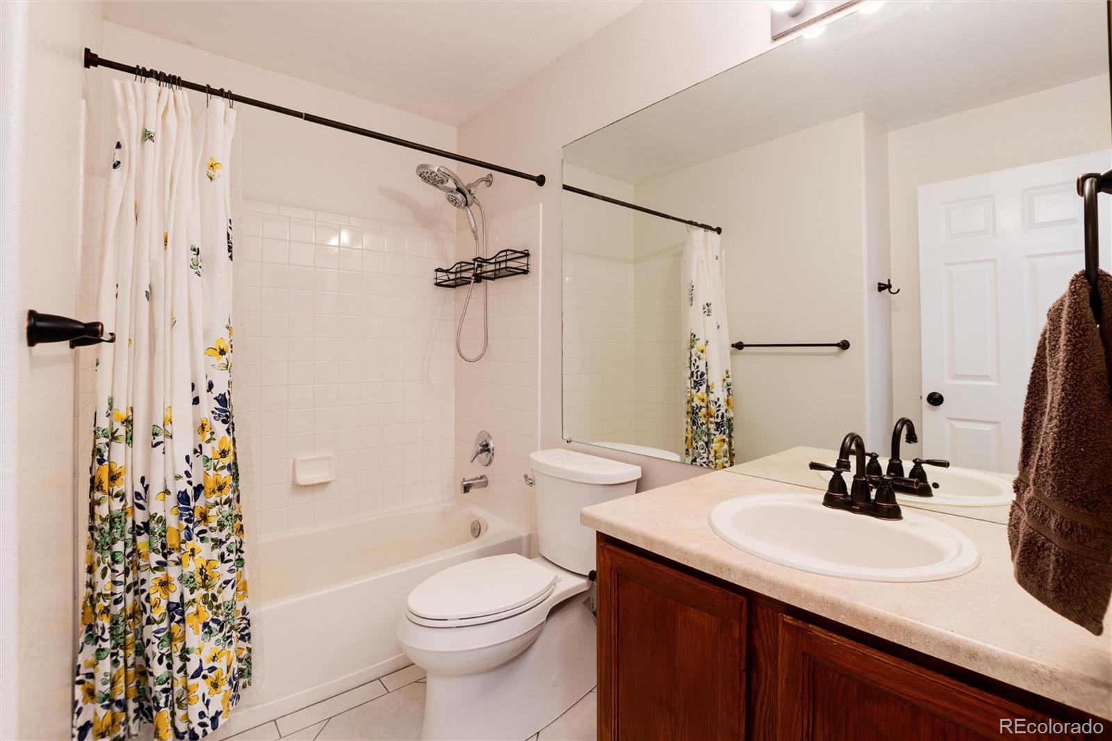 9218 Fox Fire Lane Highlands Ranch, CO 80129 - Photo 29 of 38 a bathroom with a sink toilet a mirror and shower