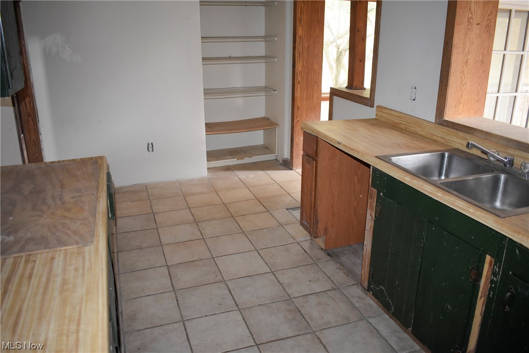 8718 Freedom Road Windham, OH 44288 - Photo 7 of 20 Kitchen featuring light tile flooring, sink, and green cabinets