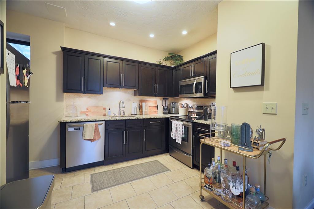 515 Lockhart Street, Unit 3 Pittsburgh, PA 15212 - Photo 10 of 27 a kitchen with granite countertop a stove top oven sink and cabinets