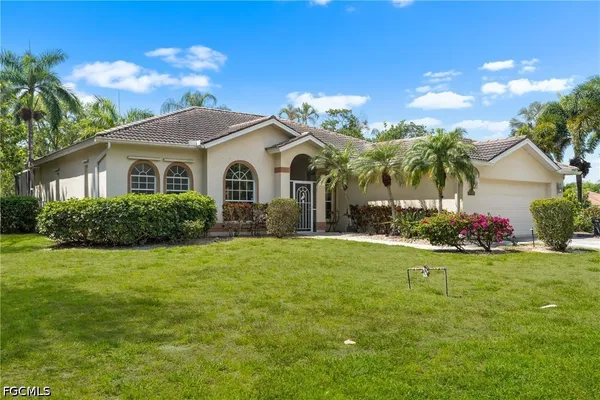 a front view of a house with a garden and yard