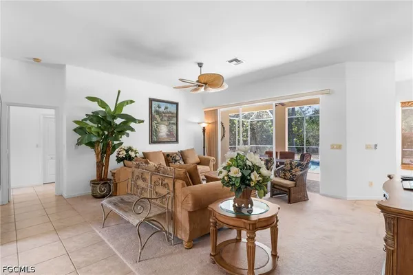 a living room with furniture a window and a potted plant