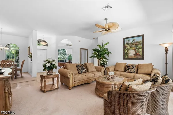 a living room with furniture flowerpot and a chandelier
