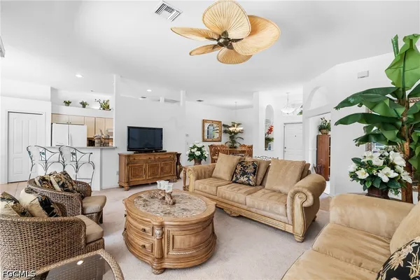 a living room with furniture flowerpot and a chandelier