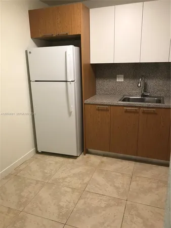 a kitchen with a refrigerator sink and cabinets
