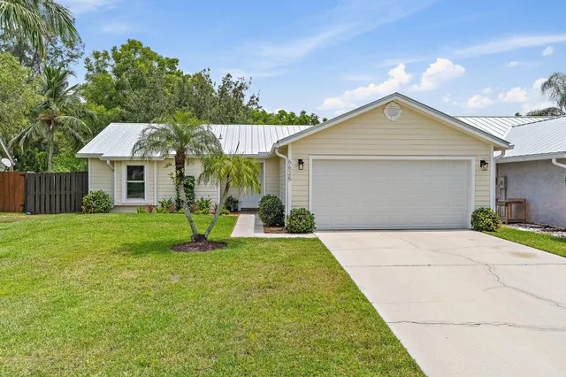 a front view of a house with a yard and trees